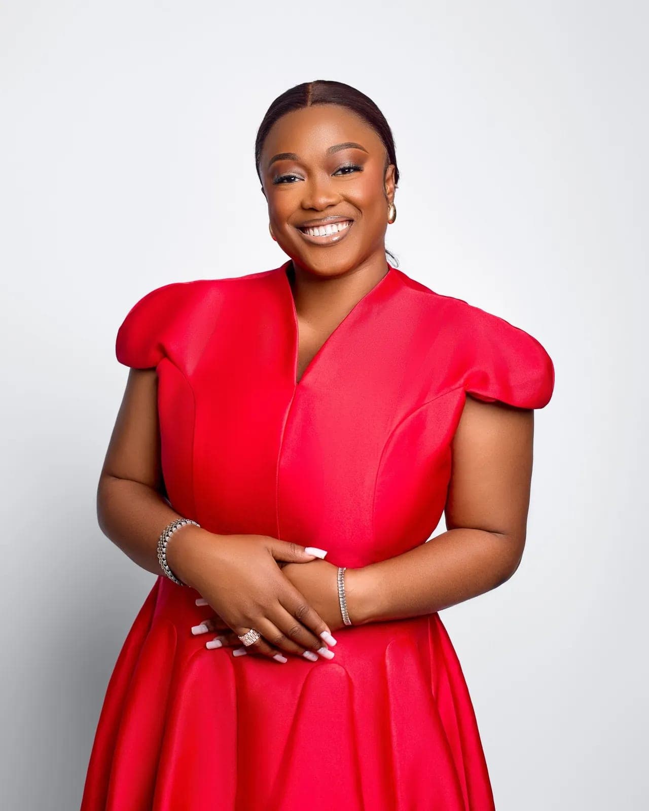 Studio portrait of Petra Odubayo smiling in a red dress